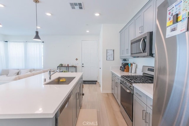 27474 Quiet View Pl, Valencia, CA 91381 - kitchen with stainless steel appliances, gray cabinetry, open floor plan, light countertops, and light wood finished floors