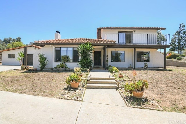 1736 Bellington Ln, Fallbrook, CA 92028 - view of front facade featuring a chimney, stucco siding, a balcony, and a tiled roof