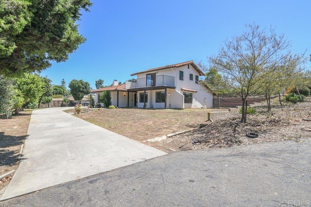 1736 Bellington Ln, Fallbrook, CA 92028 - mediterranean / spanish-style home featuring a tiled roof, a balcony, a chimney, driveway, and stucco siding