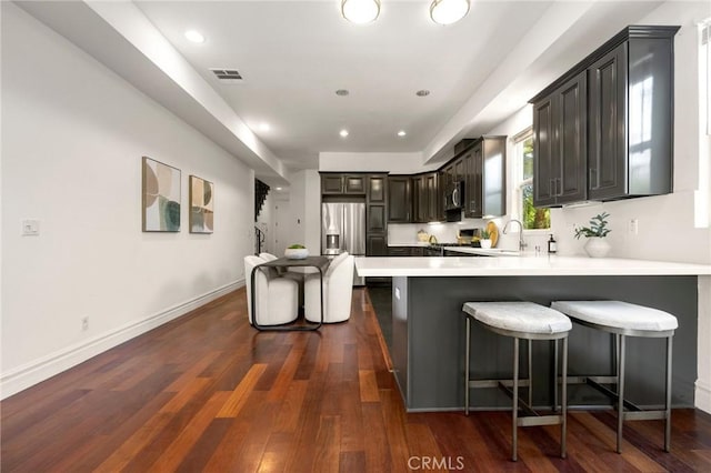 2620 Huntington Ln, Redondo Beach, CA 90278 - kitchen with appliances with stainless steel finishes, a peninsula, light countertops, dark wood-style flooring, and recessed lighting