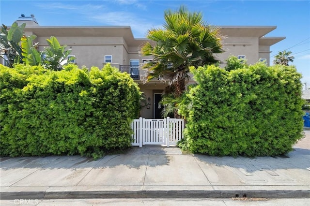 2620 Huntington Ln, Redondo Beach, CA 90278 - view of property hidden behind natural elements featuring stucco siding and a gate