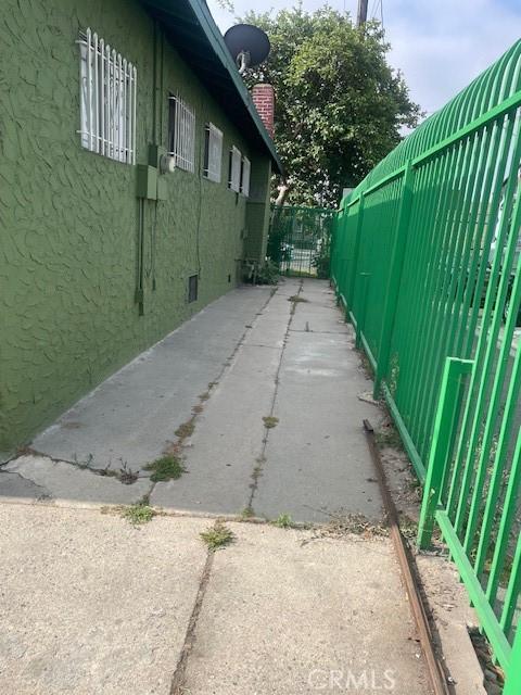 1113 E 83rd St, Los Angeles, CA 90001 - view of side of property with stucco siding and a chimney