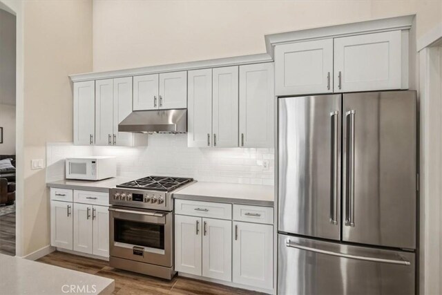232 Loretta Way, Calimesa, CA 92320 - kitchen with high end appliances, under cabinet range hood, wood finished floors, tasteful backsplash, and light countertops