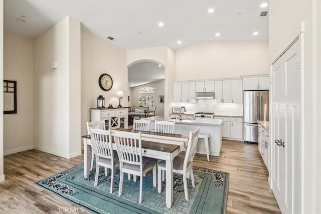 232 Loretta Way, Calimesa, CA 92320 - dining space with arched walkways, light wood-style floors, recessed lighting, and high vaulted ceiling