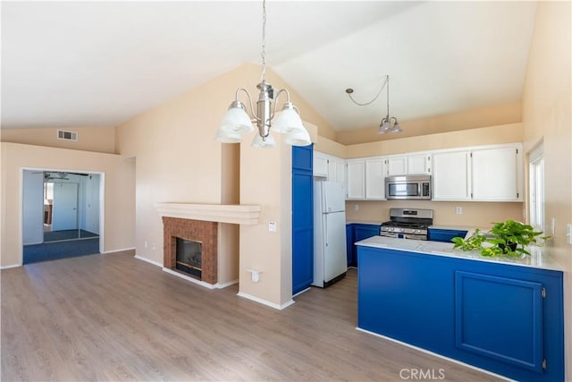 28076 Orangegrove Ave, Menifee, CA 92584 - kitchen with appliances with stainless steel finishes, lofted ceiling, a chandelier, white cabinets, and a peninsula