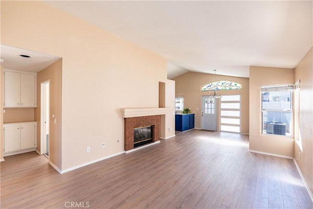 28076 Orangegrove Ave, Menifee, CA 92584 - unfurnished living room with lofted ceiling, light wood-type flooring, and a brick fireplace