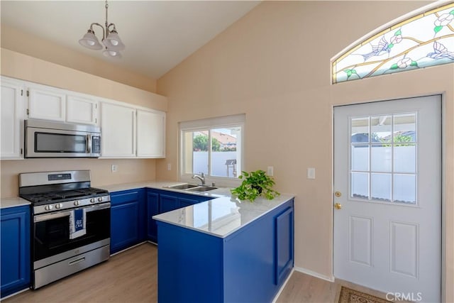 28076 Orangegrove Ave, Menifee, CA 92584 - kitchen with appliances with stainless steel finishes, a peninsula, blue cabinets, white cabinetry, and light wood finished floors