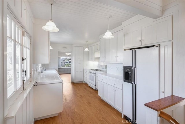 625 High Dr, Laguna Beach, CA 92651 - kitchen featuring white appliances, white cabinets, light wood-style floors, light countertops, and hanging light fixtures