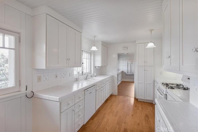 625 High Dr, Laguna Beach, CA 92651 - kitchen with tile counters, white appliances, white cabinetry, light wood-style floors, and backsplash
