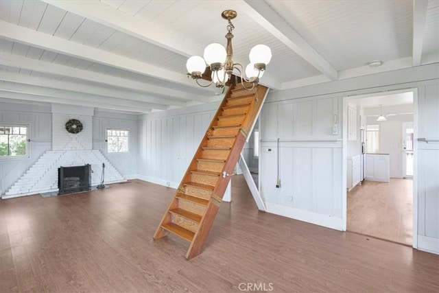 625 High Dr, Laguna Beach, CA 92651 - stairs with wood finished floors, a chandelier, a decorative wall, plenty of natural light, and beamed ceiling