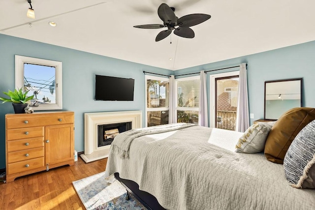 34283 Via Lopez, Dana Point, CA 92624 - bedroom with multiple windows, wood finished floors, lofted ceiling, a fireplace with raised hearth, and a ceiling fan