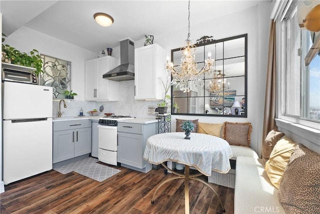 360 W Ocean Blvd Unit 1103, Long Beach, CA 90802 - kitchen featuring white appliances, wall chimney exhaust hood, backsplash, light countertops, and dark wood-style floors