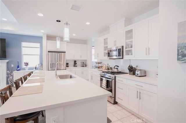 32096 Hyacinth Way, Temecula, CA 92591 - kitchen with stainless steel appliances, a breakfast bar area, glass insert cabinets, white cabinets, and recessed lighting