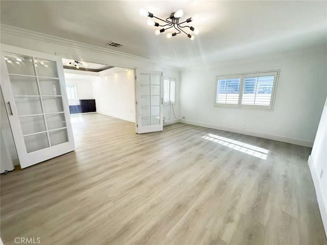 528 S Avington Ave, West Covina, CA 91790 - unfurnished living room featuring a chandelier, plenty of natural light, ornamental molding, and light wood-style floors