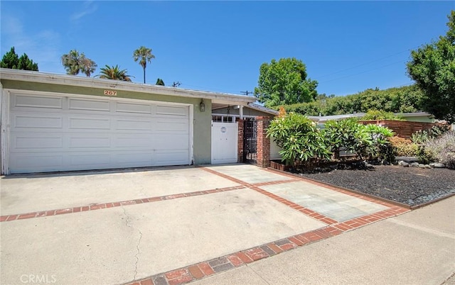 267 E 16th St, Costa Mesa, CA 92627 - view of front facade featuring a garage, stucco siding, and driveway