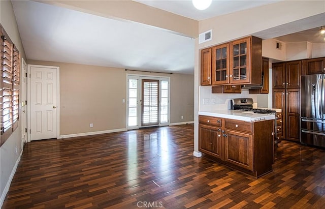 267 E 16th St, Costa Mesa, CA 92627 - kitchen featuring appliances with stainless steel finishes, light countertops, dark wood-type flooring, and glass insert cabinets