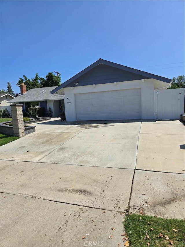 4163 Stotts St, Riverside, CA 92503 - view of front facade with driveway, an attached garage, and stucco siding