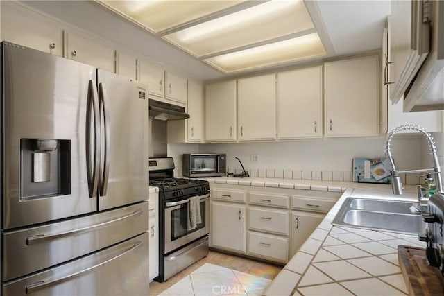 304 S Minnesota Ave, Glendora, CA 91741 - kitchen featuring appliances with stainless steel finishes, tile countertops, cream cabinetry, and under cabinet range hood