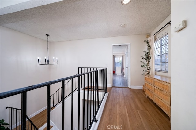 818 Live Oak Pl, Corona, CA 92882 - hall featuring an upstairs landing, a chandelier, wood finished floors, and a textured ceiling