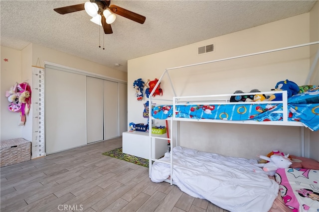 818 Live Oak Pl, Corona, CA 92882 - bedroom featuring wood finished floors, a textured ceiling, a closet, and a ceiling fan