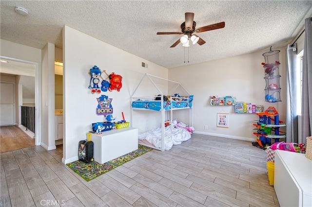818 Live Oak Pl, Corona, CA 92882 - bedroom with light wood finished floors, a textured ceiling, and a ceiling fan
