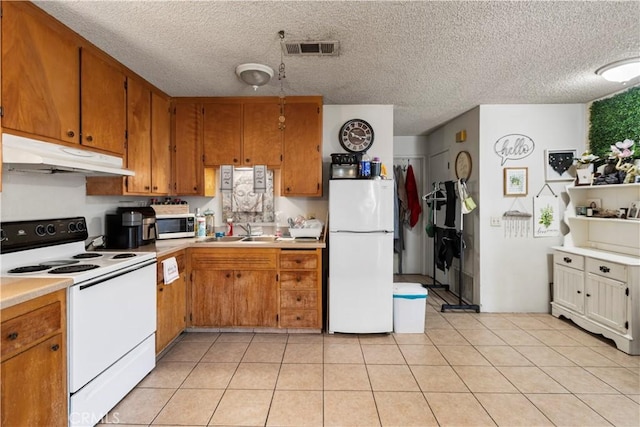 351 W 19th St, Merced, CA 95340 - kitchen featuring white appliances, under cabinet range hood, light countertops, brown cabinets, and a textured ceiling