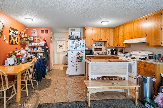 351 W 19th St, Merced, CA 95340 - kitchen with white appliances, under cabinet range hood, a textured ceiling, light tile patterned floors, and light countertops