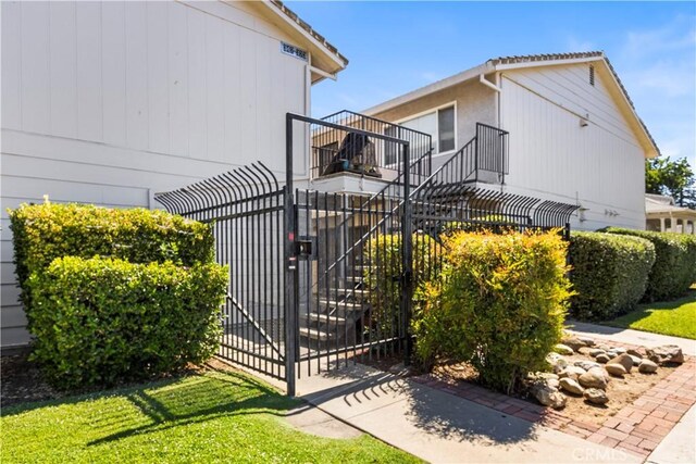 351 W 19th St, Merced, CA 95340 - view of home's exterior with a gate, a balcony, and stairs