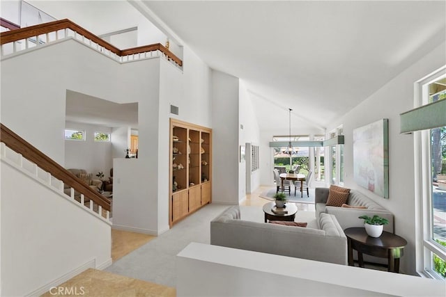 23256 Arelo Ct, Laguna Niguel, CA 92677 - carpeted living room with high vaulted ceiling, a chandelier, healthy amount of natural light, and stairway