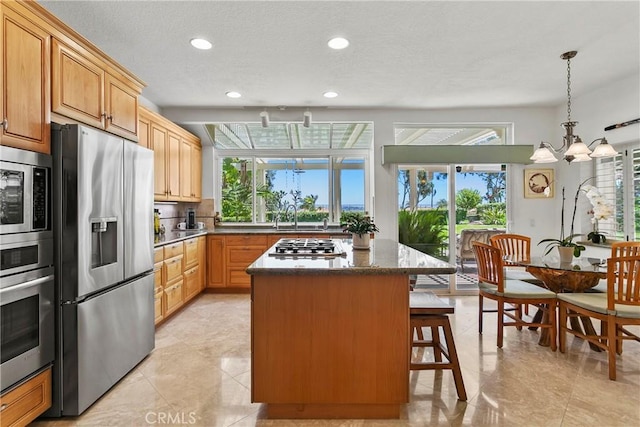 23256 Arelo Ct, Laguna Niguel, CA 92677 - kitchen featuring stainless steel appliances, a center island, recessed lighting, a breakfast bar, and dark stone counters