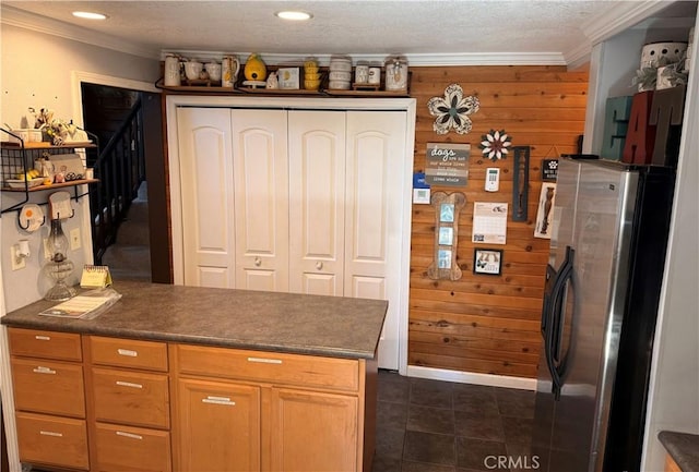 9312 Mountain Meadow Rd, Shingletown, CA 96088 - kitchen featuring crown molding, freestanding refrigerator, dark countertops, wood walls, and dark tile patterned floors
