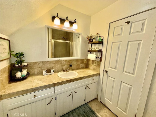 9312 Mountain Meadow Rd, Shingletown, CA 96088 - bathroom with vaulted ceiling, vanity, a stall shower, tile patterned floors, and tasteful backsplash