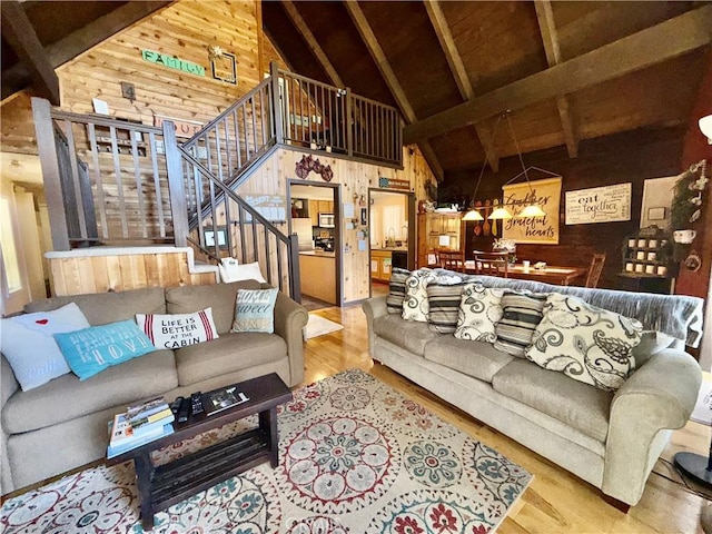 9312 Mountain Meadow Rd, Shingletown, CA 96088 - living room with wood walls, wood finished floors, high vaulted ceiling, stairs, and beamed ceiling