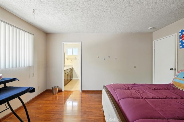 11813 Colima Rd, Whittier, CA 90604 - bedroom with light wood finished floors, a textured ceiling, and connected bathroom