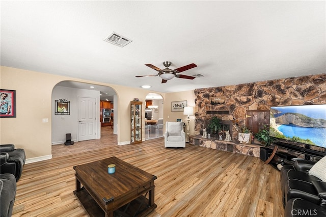 19082 Tecumseh Rd, Apple Valley, CA 92307 - living area with arched walkways, ceiling fan, light wood-type flooring, and a fireplace
