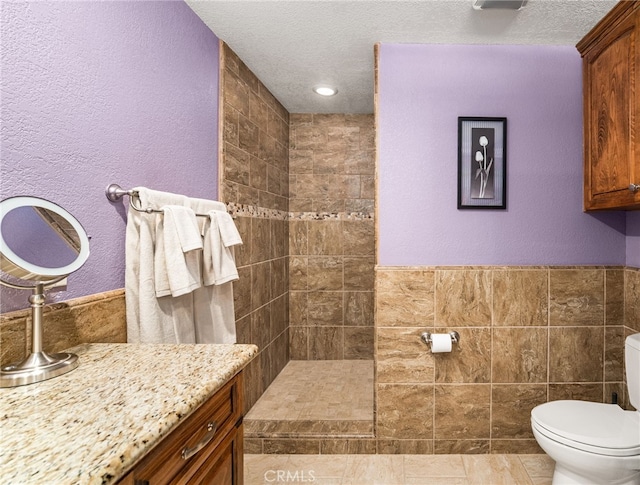 19082 Tecumseh Rd, Apple Valley, CA 92307 - full bathroom featuring tiled shower, vanity, tile walls, a textured ceiling, and a textured wall