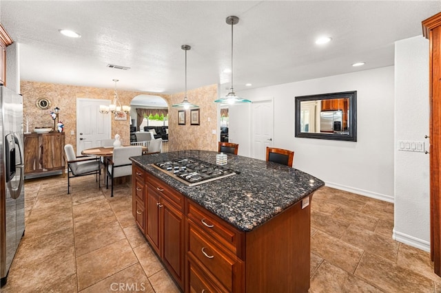 19082 Tecumseh Rd, Apple Valley, CA 92307 - kitchen featuring appliances with stainless steel finishes, a center island, a chandelier, hanging light fixtures, and dark stone counters