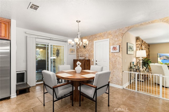 19082 Tecumseh Rd, Apple Valley, CA 92307 - dining space with a chandelier, arched walkways, light tile patterned floors, and a textured ceiling