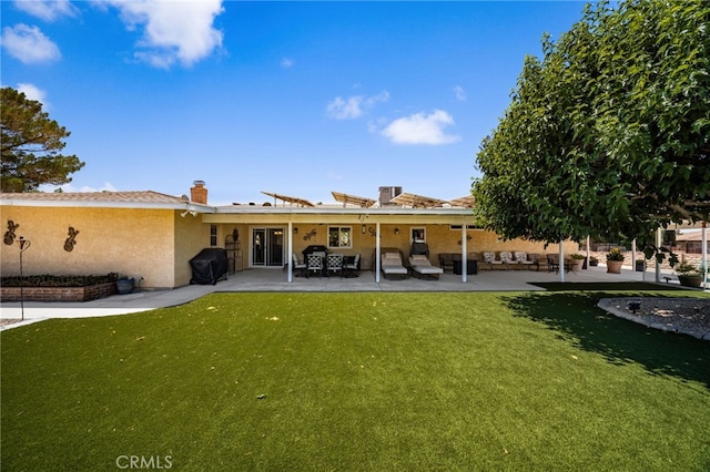 19082 Tecumseh Rd, Apple Valley, CA 92307 - back of property with stucco siding, a lawn, and a patio area