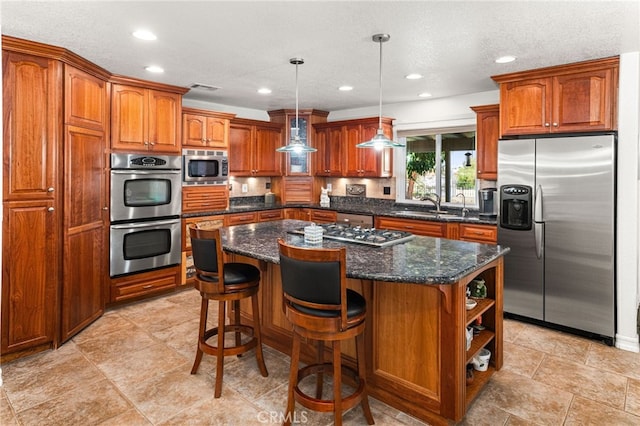 19082 Tecumseh Rd, Apple Valley, CA 92307 - kitchen with appliances with stainless steel finishes, brown cabinets, a center island, recessed lighting, and dark stone counters