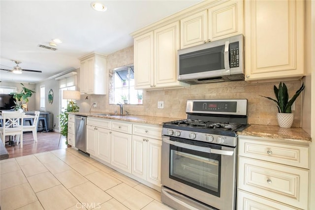 417 N Lamer St, Burbank, CA 91506 - kitchen featuring stainless steel appliances, cream cabinetry, light stone countertops, tasteful backsplash, and recessed lighting