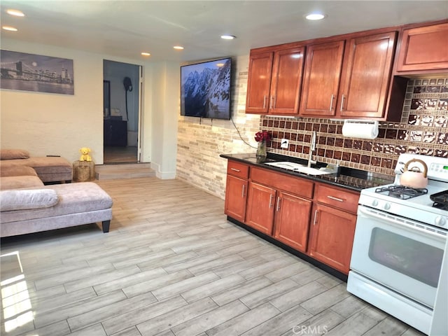 8626 Laurel Canyon Blvd, Sun Valley, CA 91352 - kitchen with white gas stove, backsplash, light wood finished floors, recessed lighting, and open floor plan