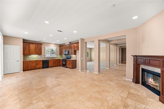 1909 Crystal Cove Ct, Redlands, CA 92374 - kitchen with black appliances, decorative backsplash, a glass covered fireplace, brown cabinetry, and recessed lighting