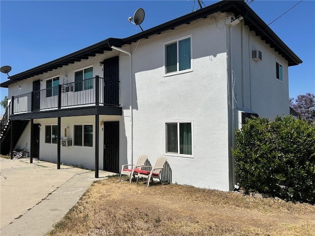 24188 Clover Ave, Moreno Valley, CA 92551 - back of property featuring stucco siding, a patio area, stairway, and a balcony