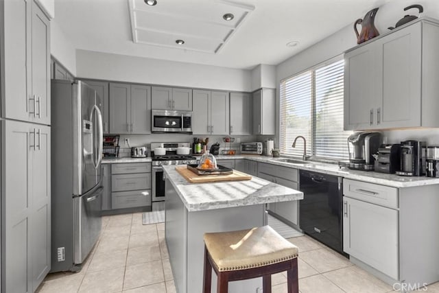 32110 Camino Herencia, Temecula, CA 92592 - kitchen with appliances with stainless steel finishes, gray cabinets, a center island, and light tile patterned floors