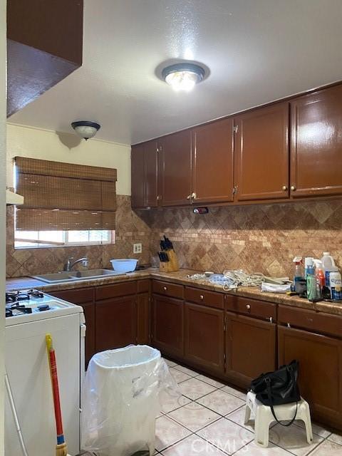 1618 W Burnett, Long Beach, CA 90810 - kitchen featuring white stove, tasteful backsplash, light tile patterned flooring, and range hood