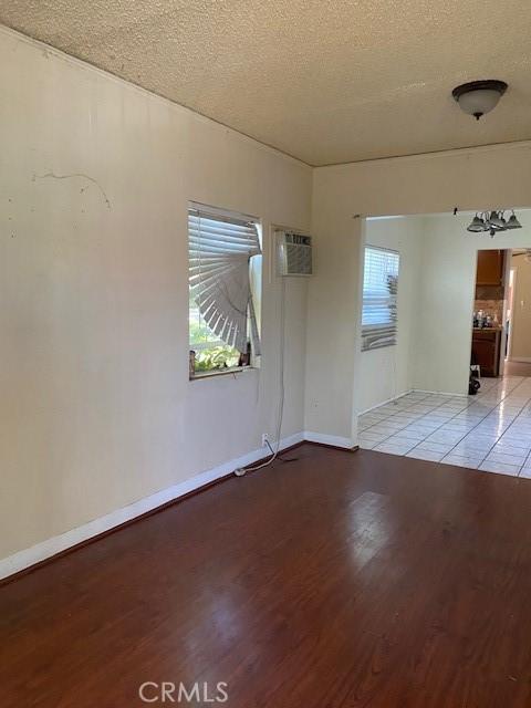 1618 W Burnett, Long Beach, CA 90810 - unfurnished room featuring a textured ceiling, plenty of natural light, light wood-style floors, and a wall mounted air conditioner