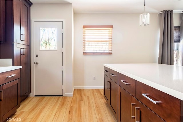239 W Hillcrest Blvd, Inglewood, CA 90301 - kitchen featuring light wood-style flooring, light countertops, a chandelier, and pendant lighting