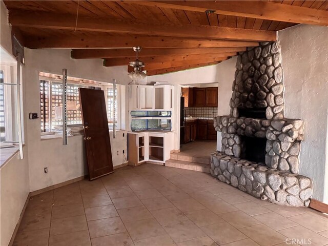 73455 Helms Rd, Desert Hot Springs, CA 92241 - unfurnished living room featuring a wood ceiling with exposed beams, light tile patterned floors, a stone fireplace, and a ceiling fan
