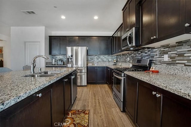 1246 Venice Ave, Mentone, CA 92359 - kitchen with appliances with stainless steel finishes, light wood-type flooring, light stone countertops, tasteful backsplash, and recessed lighting